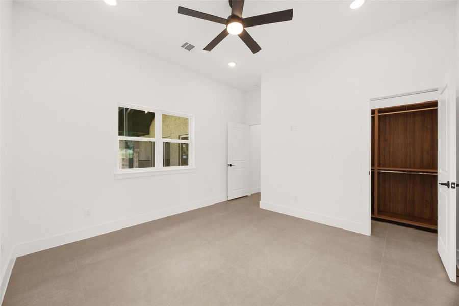 Another view of the 3rd bedroom showing walk in closet with custom designed built-ins.