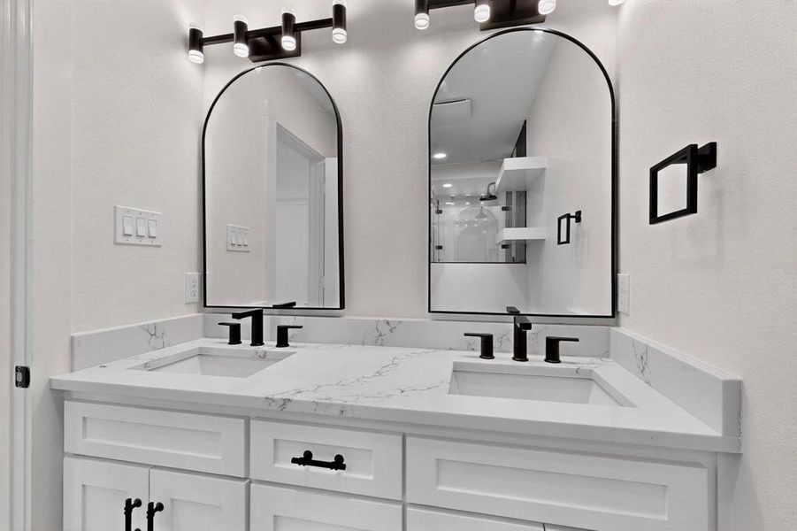 Full bath with double vanity and a stall shower