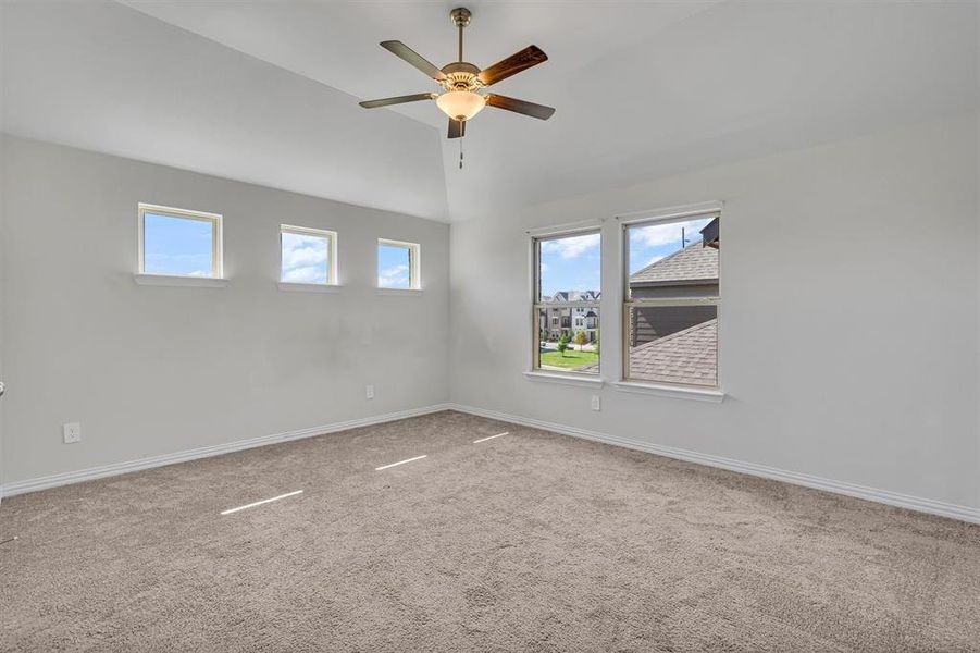 Spare room with carpet flooring, lofted ceiling, and ceiling fan