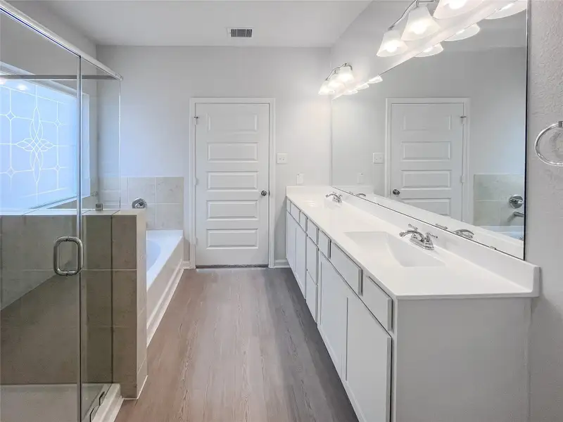 The Waring III- Primary Bathroom with Dual Vanities, Separate Garden tub and Walk-in Shower. Sample image for illustration; upgrades, options, and colors may vary.