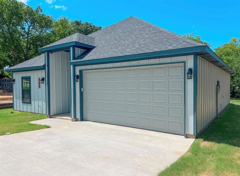 View of front of property with a garage and a front yard