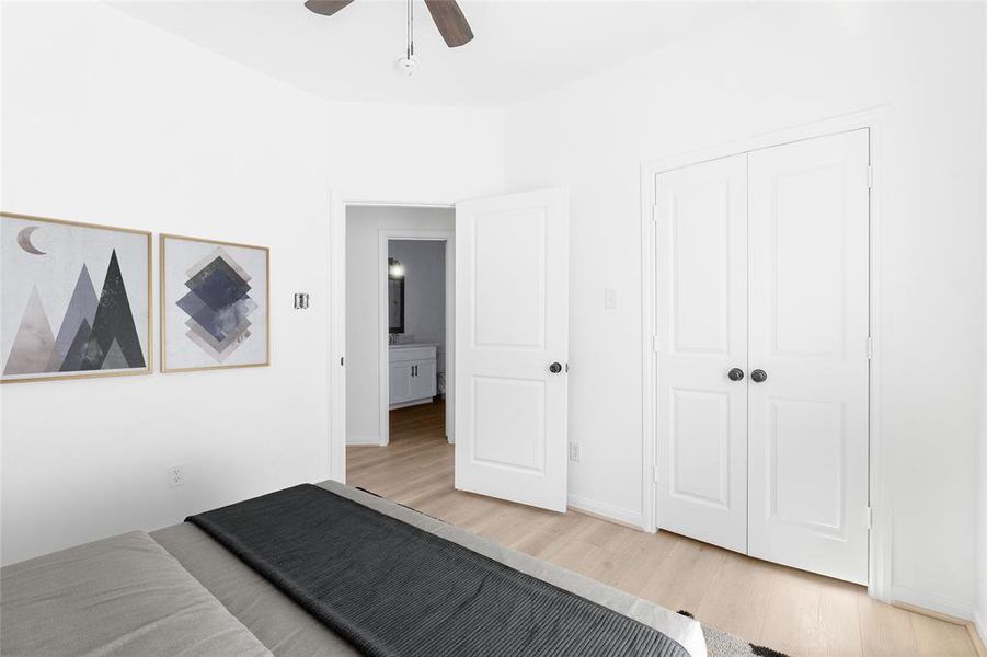 Another view of the secondary bedroom showcases the closet doors and a glimpse of the hallway, leading to the nearby secondary bathroom. (Photo may be enhanced and may include virtual staging)