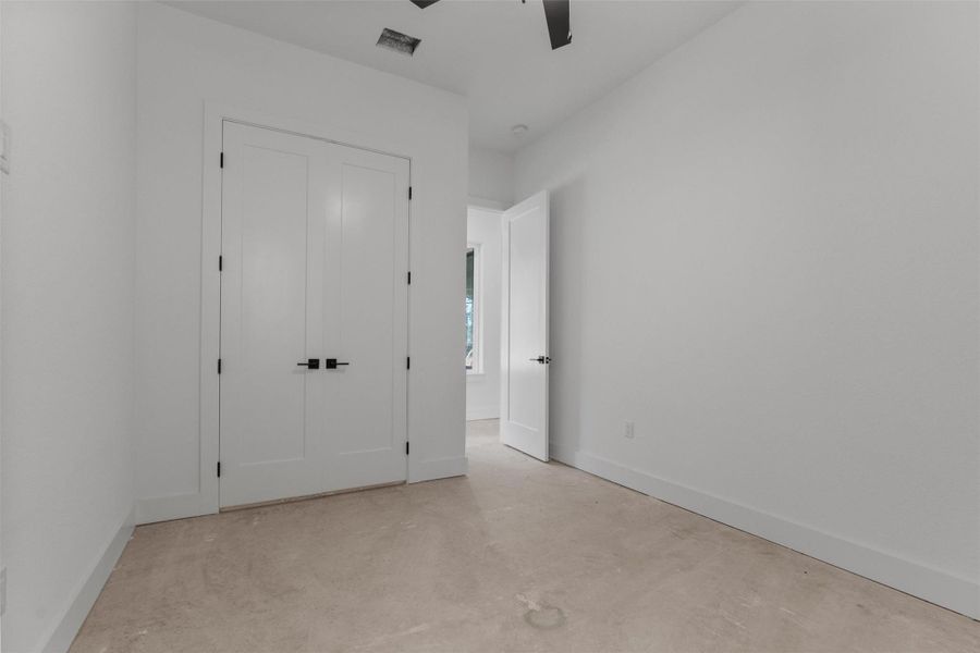 Unfurnished bedroom featuring unfinished concrete floors, ceiling fan, and a closet Unfurnished bedroom featuring unfinished concrete floors, ceiling fan, and a closet