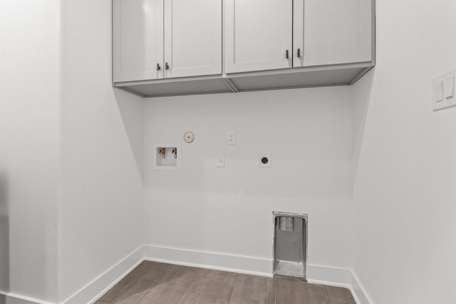 Laundry room featuring hookup for a washing machine, hookup for a gas dryer, light wood-type flooring, cabinet space, and electric dryer hookup