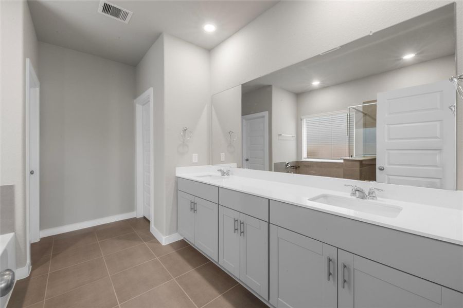 Well-appointed primary bathroom featuring a spacious layout with modern fixtures, ample counter space, and a clean, functional design for everyday convenience.