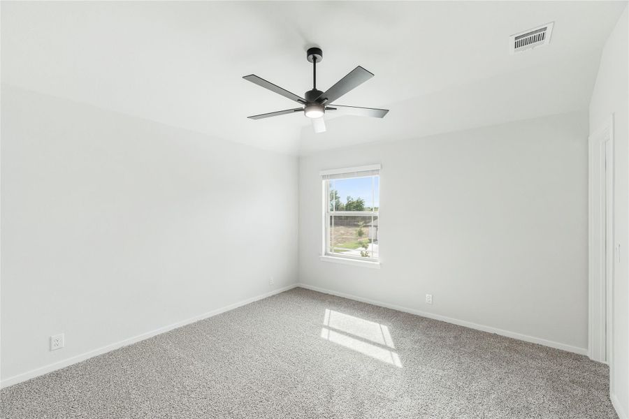 Empty bedroom with gray carpet, vaulted ceiling, ceiling fan, and single window