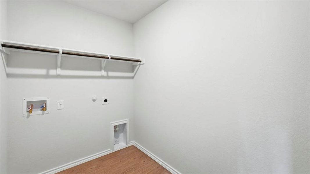 Laundry room featuring gas dryer hookup, wood finished floors, washer hookup, and electric dryer hookup Laundry room featuring gas dryer hookup, wood finished floors, washer hookup, and electric dryer hookup