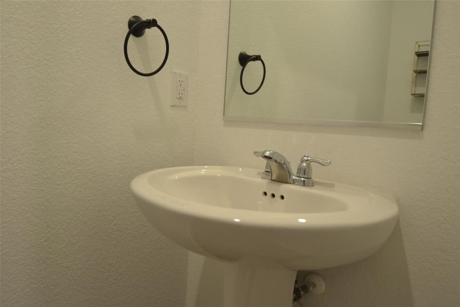 Bathroom featuring a sink and a textured wall