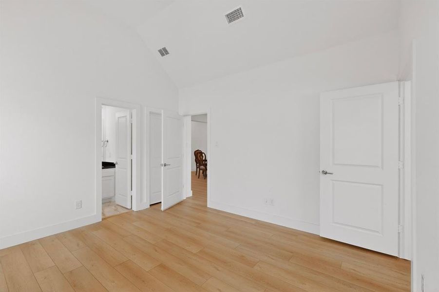 Spacious room with vaulted ceiling and light wood-finish flooring Spacious room with vaulted ceiling and light wood-finish flooring