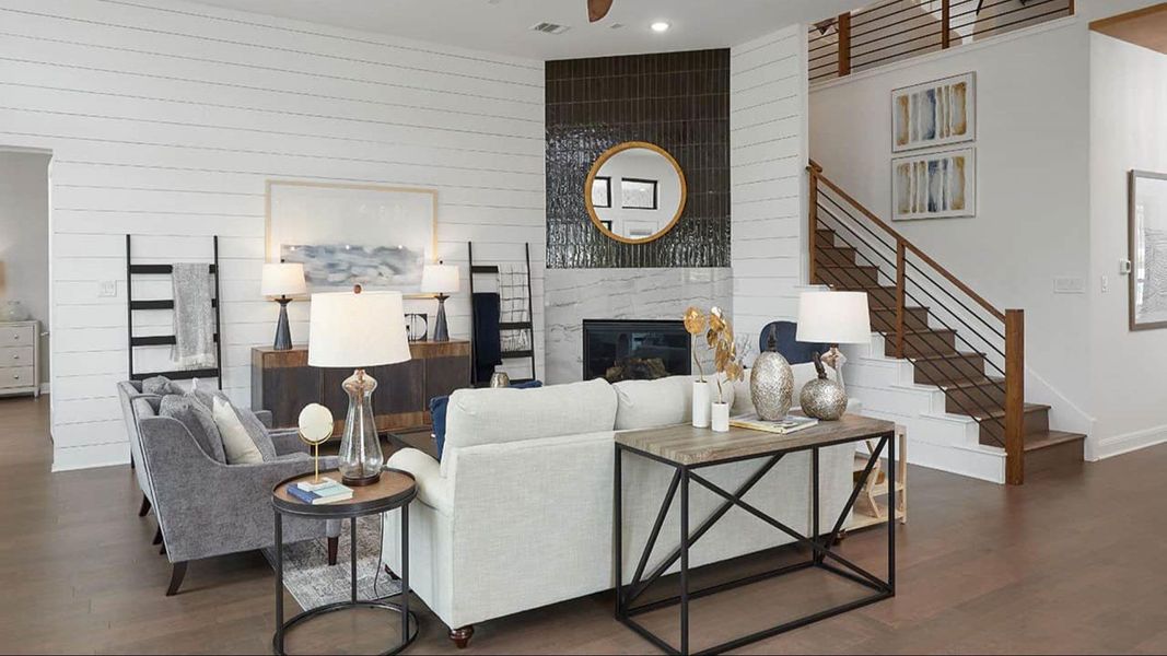 Living room featuring wooden walls, a fireplace, dark wood-style flooring, stairs, and recessed lighting Living room featuring wooden walls, a fireplace, dark wood-style flooring, stairs, and recessed lighting