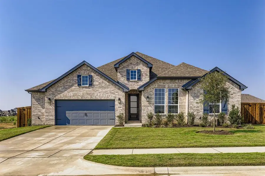 View of front of home featuring brick siding, driveway, roof with shingles, and an attached garage