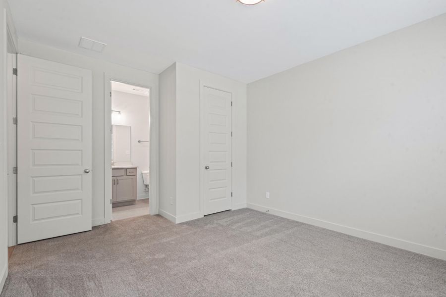 Carpeted room with light gray walls, white baseboards, and a flush mount ceiling light Carpeted room with light gray walls, white baseboards, and a flush mount ceiling light