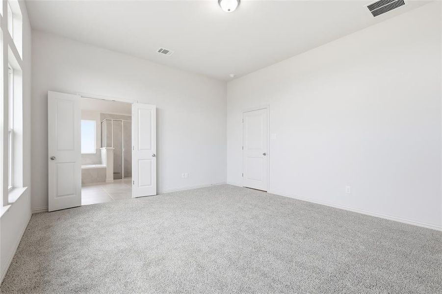 Unfurnished bedroom with light colored carpet and baseboards Unfurnished bedroom with light colored carpet and baseboards
