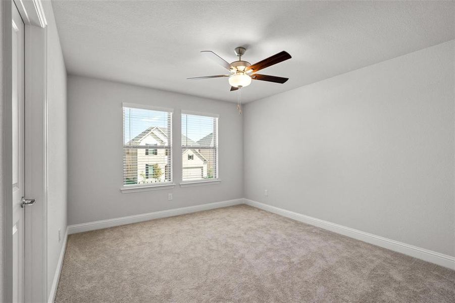 Spare room featuring ceiling fan and light colored carpet