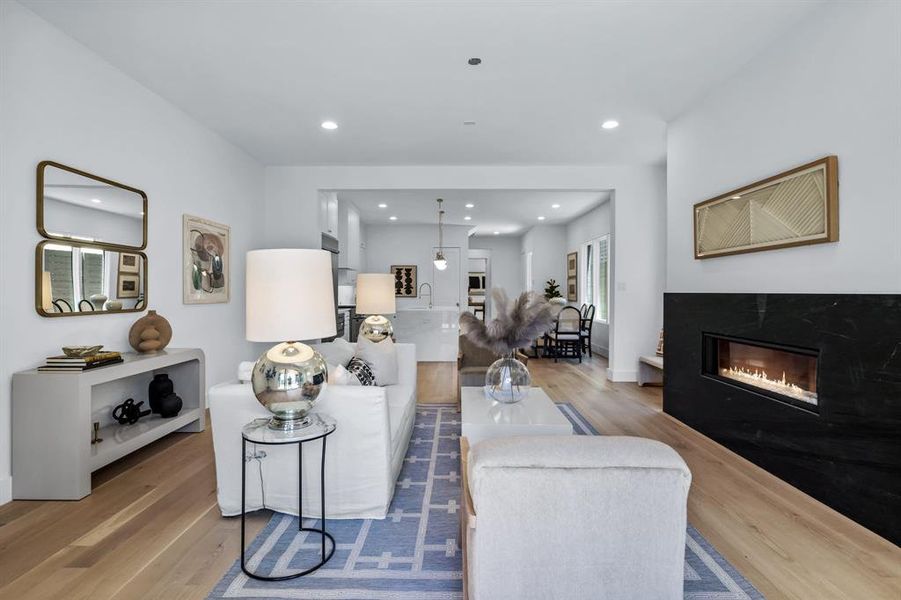 Living room featuring a high end fireplace and light wood-type flooring