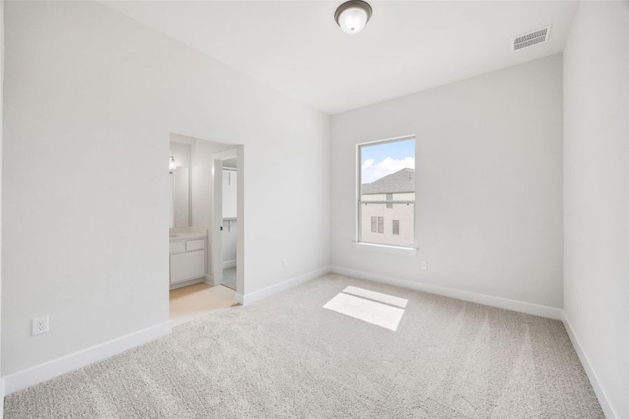 Unfurnished bedroom featuring light colored carpet and ensuite bathroom Unfurnished bedroom featuring light colored carpet and ensuite bathroom
