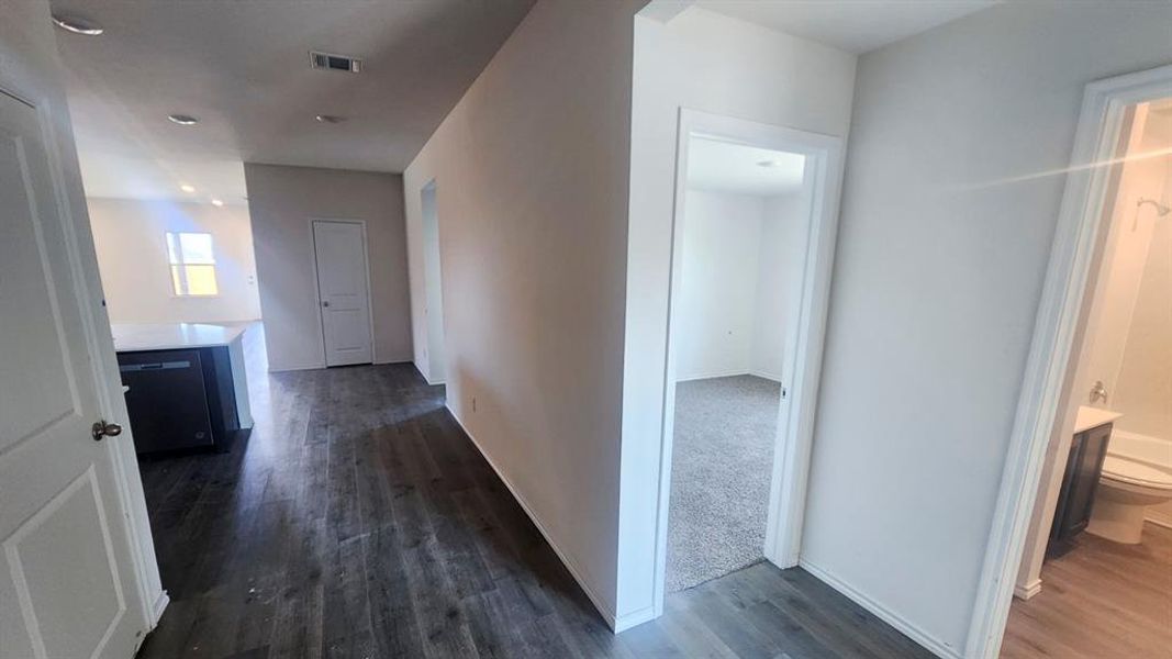 Interior hallway featuring wood-finish flooring, white walls, and recessed lighting