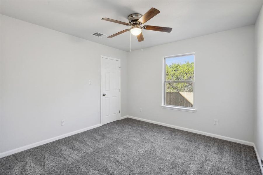 Carpeted spare room with ceiling fan