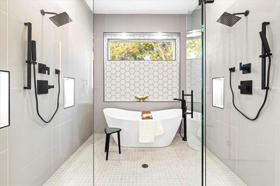 Bathroom featuring plenty of natural light, tile patterned flooring, a tile shower, and tile walls