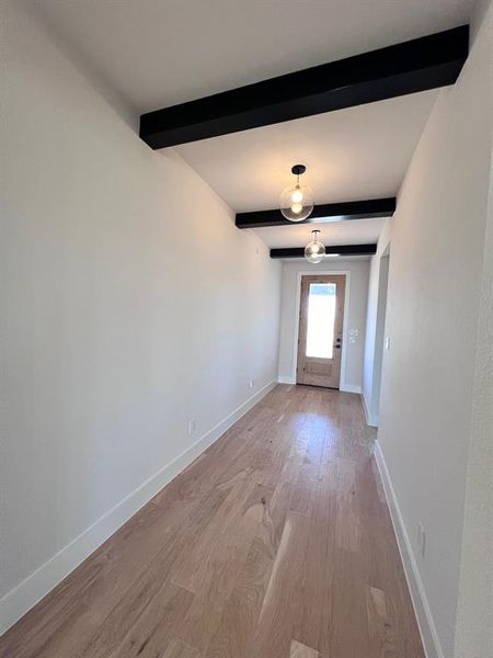 Entry with stained front and door and decorative beams and light fixtures.