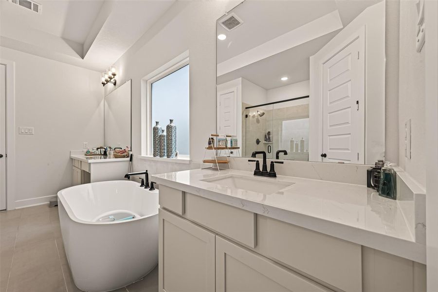 Enjoy separate vanities and a relaxing soaking tub in the luxurious primary bathroom. Enjoy separate vanities and a relaxing soaking tub in the luxurious primary bathroom.