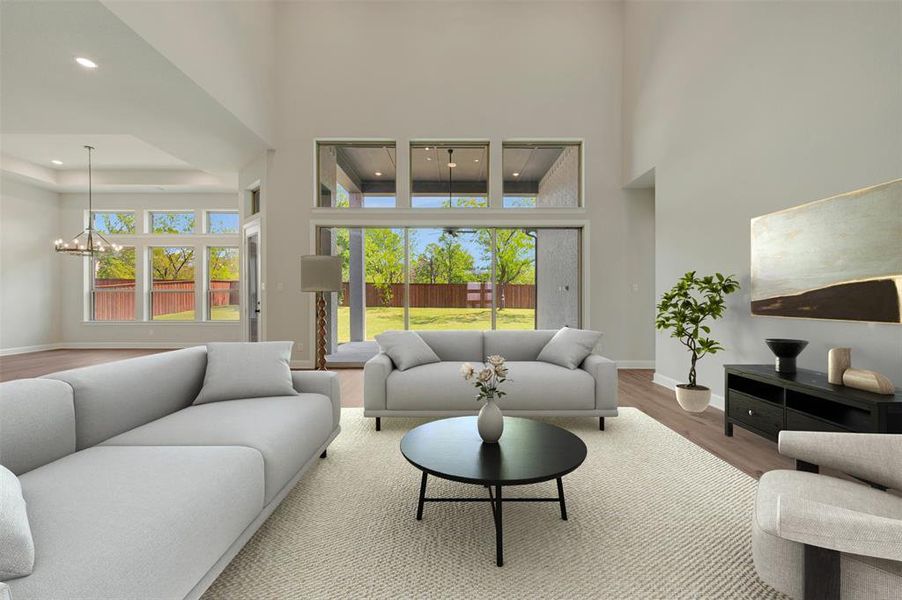 Living area with wood finished floors, suspended lighting, and a high ceiling