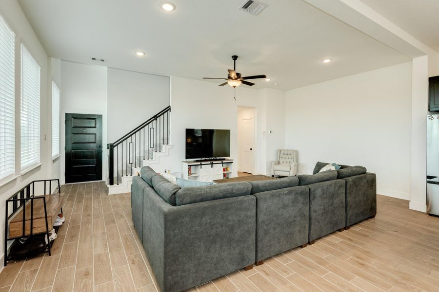 View from the dining area, showcasing the front door, stairs, and family room.