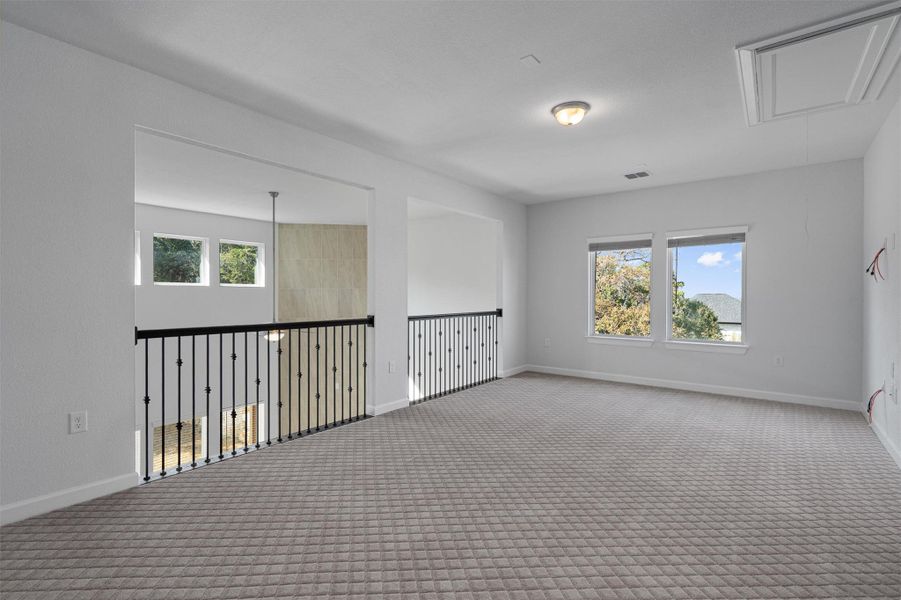 Carpeted spare room with attic access and baseboards Carpeted spare room with attic access and baseboards