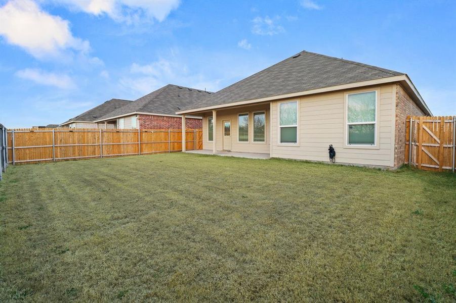Back of house featuring a patio area, a fenced backyard, a gate, and brick siding