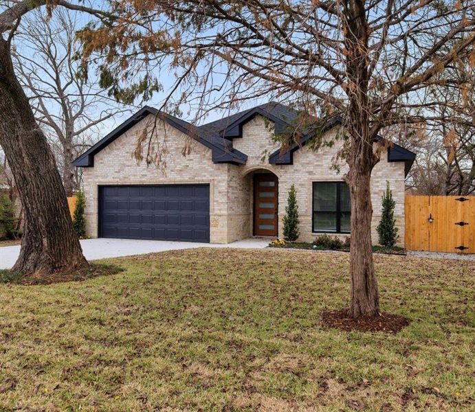 View of front of property with a front yard and a garage