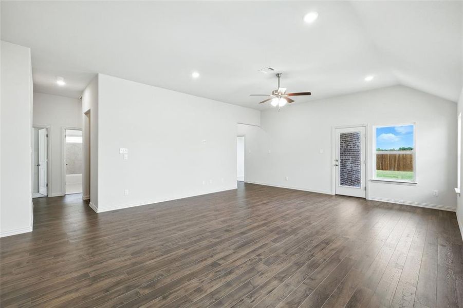 Unfurnished living room featuring recessed lighting, dark wood finished floors, lofted ceiling, and a ceiling fan Unfurnished living room featuring recessed lighting, dark wood finished floors, lofted ceiling, and a ceiling fan