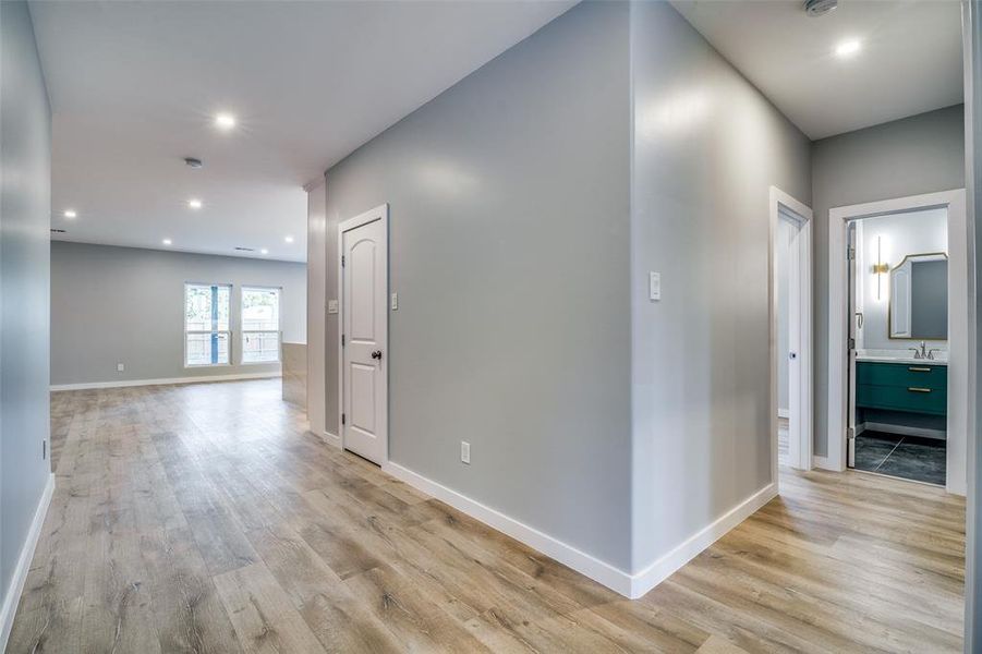 Hallway with light wood-type flooring and sink