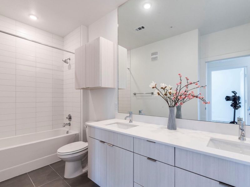 Bathroom with double vanity, tile flooring, and a tub / shower combination Bathroom with double vanity, tile flooring, and a tub / shower combination