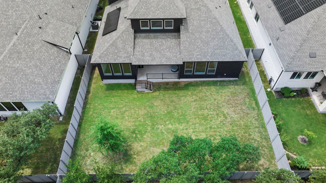 Expansive fenced backyard as seen from above, offering ample space for outdoor living, gardening, or play.
