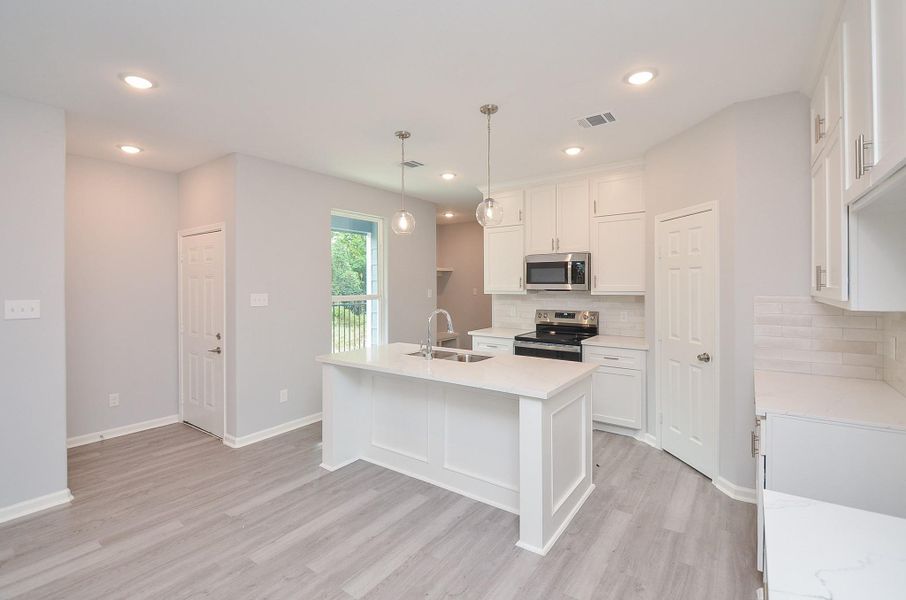 Central island doubles as prep space and breakfast bar—perfect for quick bites or coffee time.