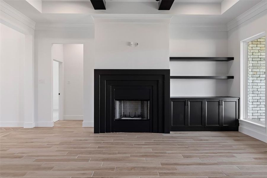 Unfurnished living room with light wood-type flooring, plenty of natural light, and beamed ceiling