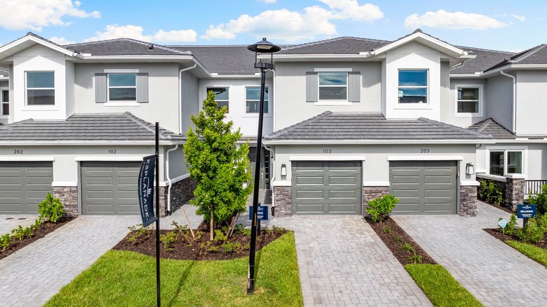 Front exterior of a new home in Esplanade by the Islands Coach Homes, Naples, FL, highlighting curb appeal (Image 1). Front exterior of a new home in Esplanade by the Islands Coach Homes, Naples, FL, highlighting curb appeal (Image 1).