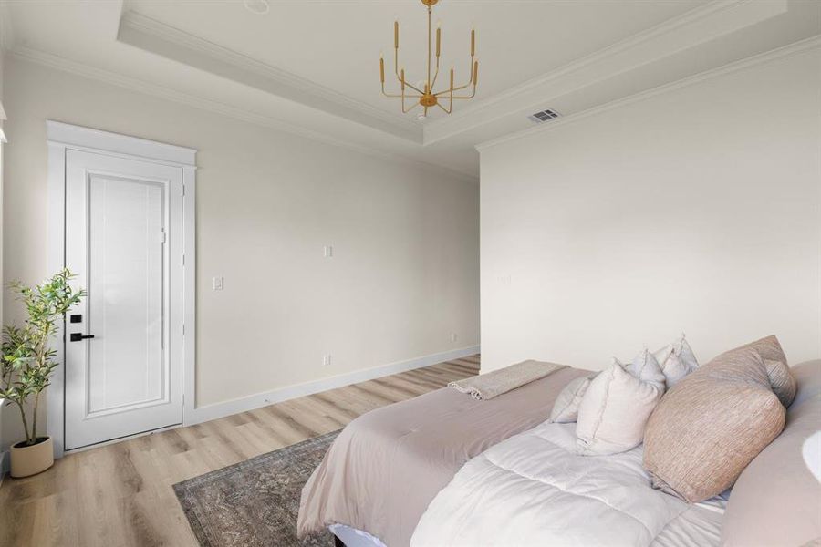 Master Bedroom with a notable chandelier, a raised ceiling, and ornamental molding