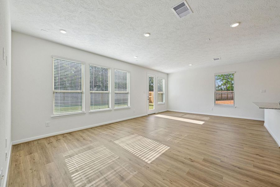 Flooded with natural light from large windows, the Great Room feels bright and airy. Recessed lighting adds to the welcoming atmosphere, perfect for gathering with family and guests.