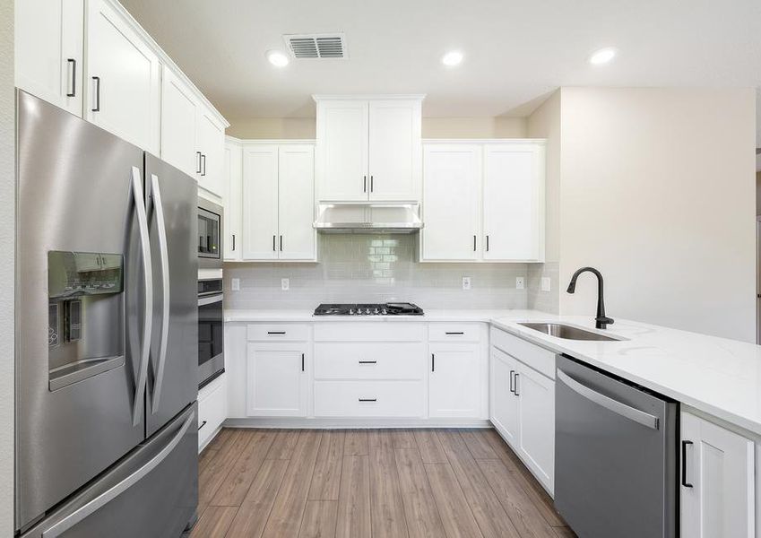 Beautiful white kitchen with stainless steel appliances.