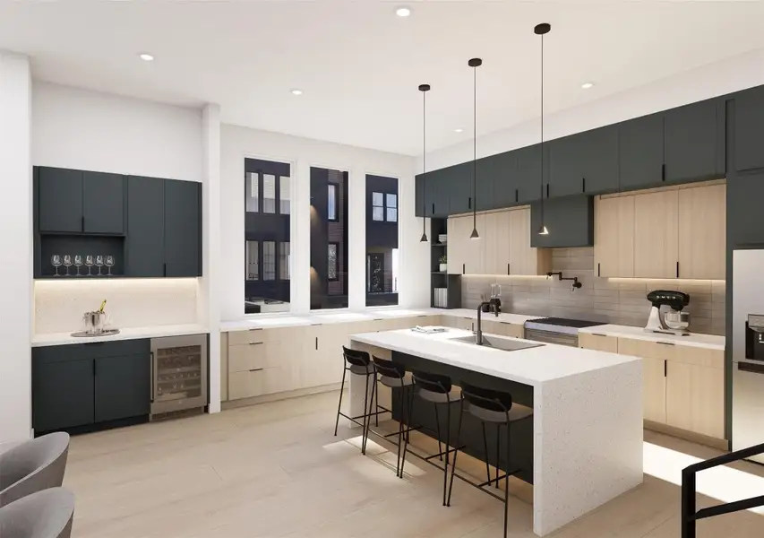 A stunning designer kitchen featuring sleek two-tone cabinetry, quartz waterfall island, modern pendant lighting, and oversized windows!