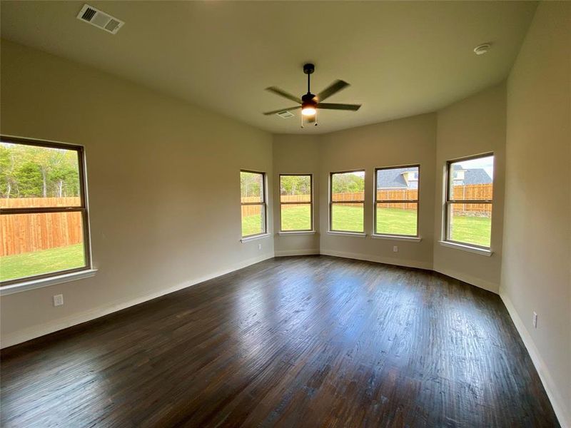 Huge master bedroom with bay window, hardwood floors, vaulted ceiling, and ceiling fan.