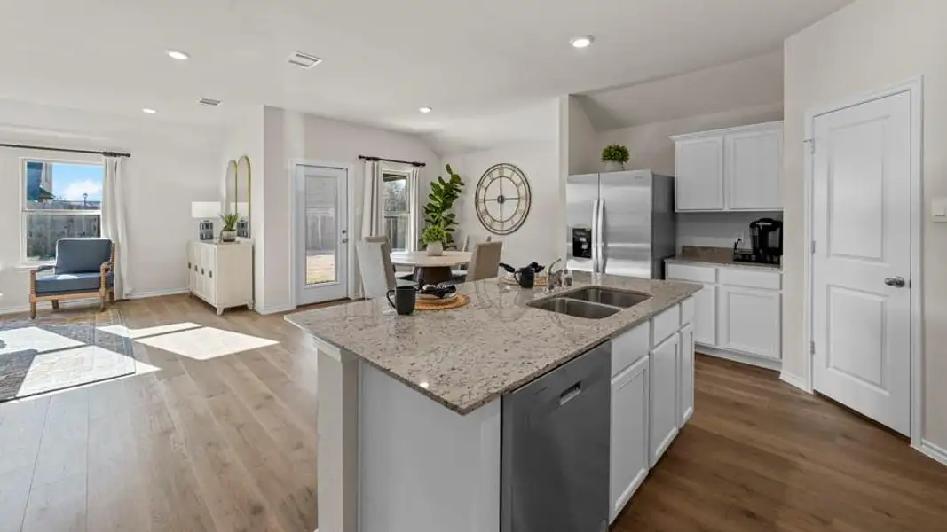 Kitchen featuring white cabinetry, stainless steel appliances, dark wood finished floors, light stone countertops, and open floor plan