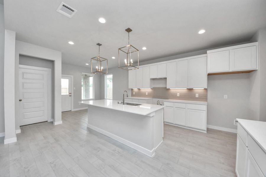The extended counter area adds both practicality and style, making meal preparation a breeze. Every detail is thoughtfully designed to enhance the kitchen's functionality and aesthetic appeal. Sample photo of completed home with similar floor plan. Actual colors and selections may vary.