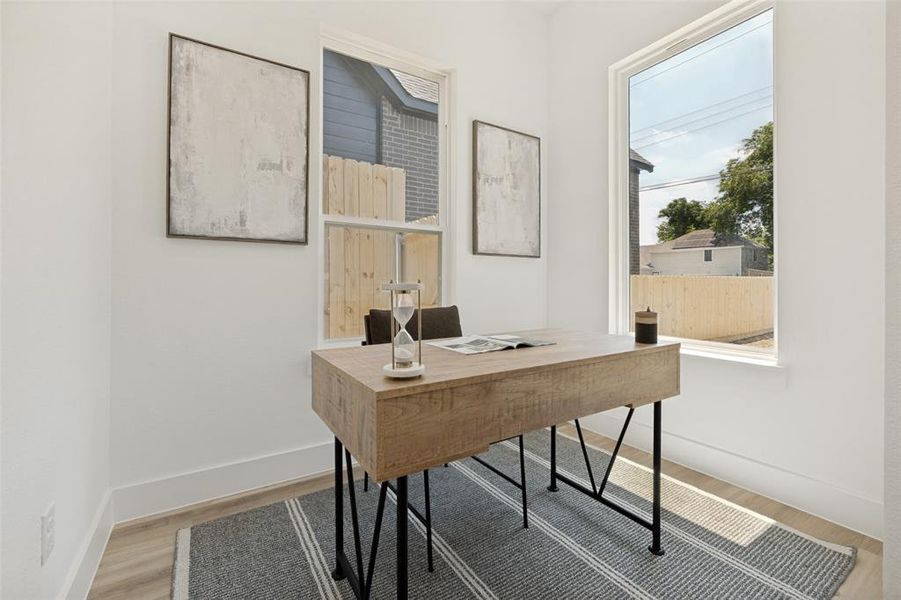 Bright room featuring two large windows, white walls, light wood-finish flooring, and white baseboards Bright room featuring two large windows, white walls, light wood-finish flooring, and white baseboards