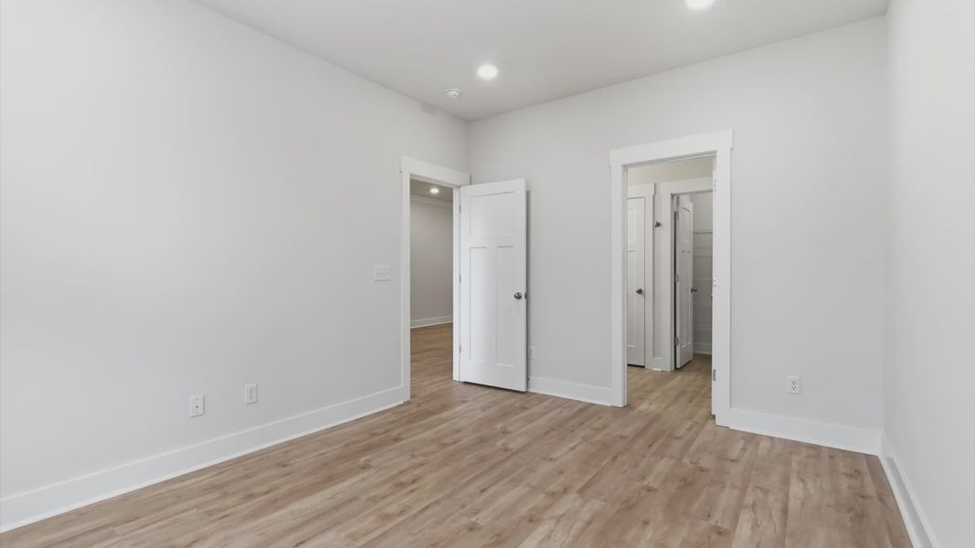Serene and stylish primary bedroom featuring hardwood flooring and a thoughtful, modern layout at Pelham Crossing