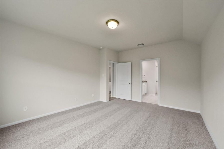 Sun-lit, versatile room with plush carpeting—perfect for a bedroom or home office.