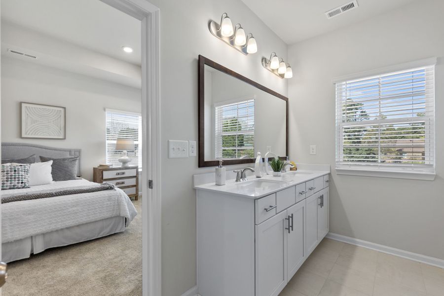 A bathroom with a sink and a bed.