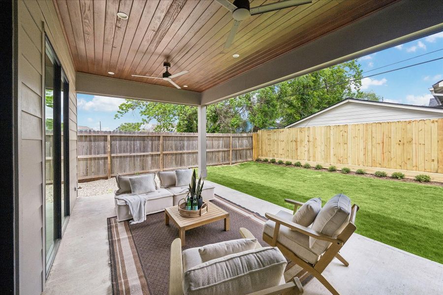 Holly bushes line the fence, creating a backdrop for relaxing or entertaining in the backyard. Enjoy this space year-round with the comfort of ceiling fans and recessed lighting.