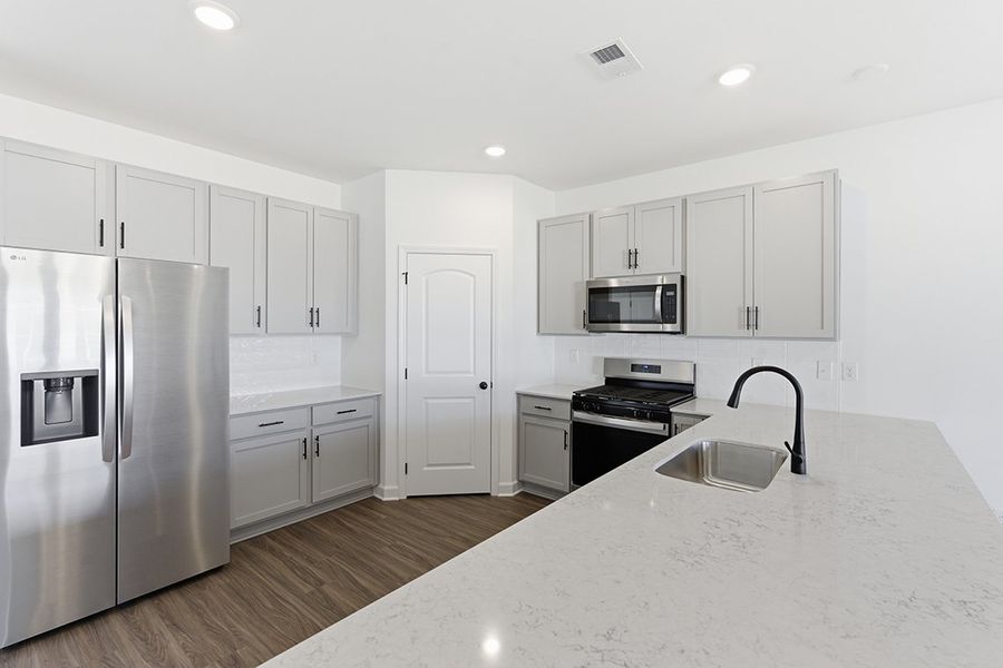 A kitchen with white cabinets.